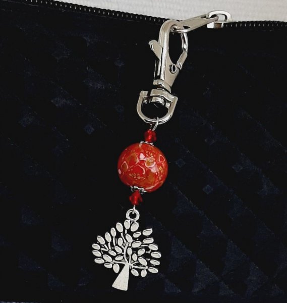 n&oslash;glering i s&oslash;lv med symbolet livets tr&aelig; og h&aring;ndlavet perle i r&oslash;d og guld