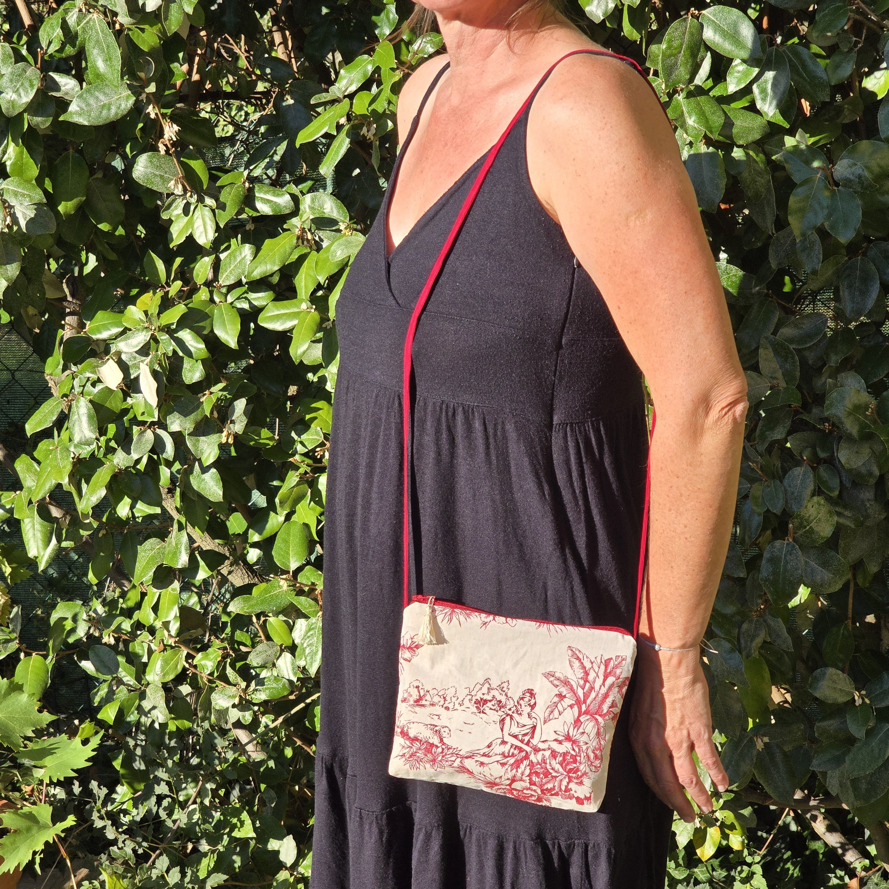 Pochette avec bandoulière en tissu toile de Jouy bordeaux et écru agrémentée d'un pompon