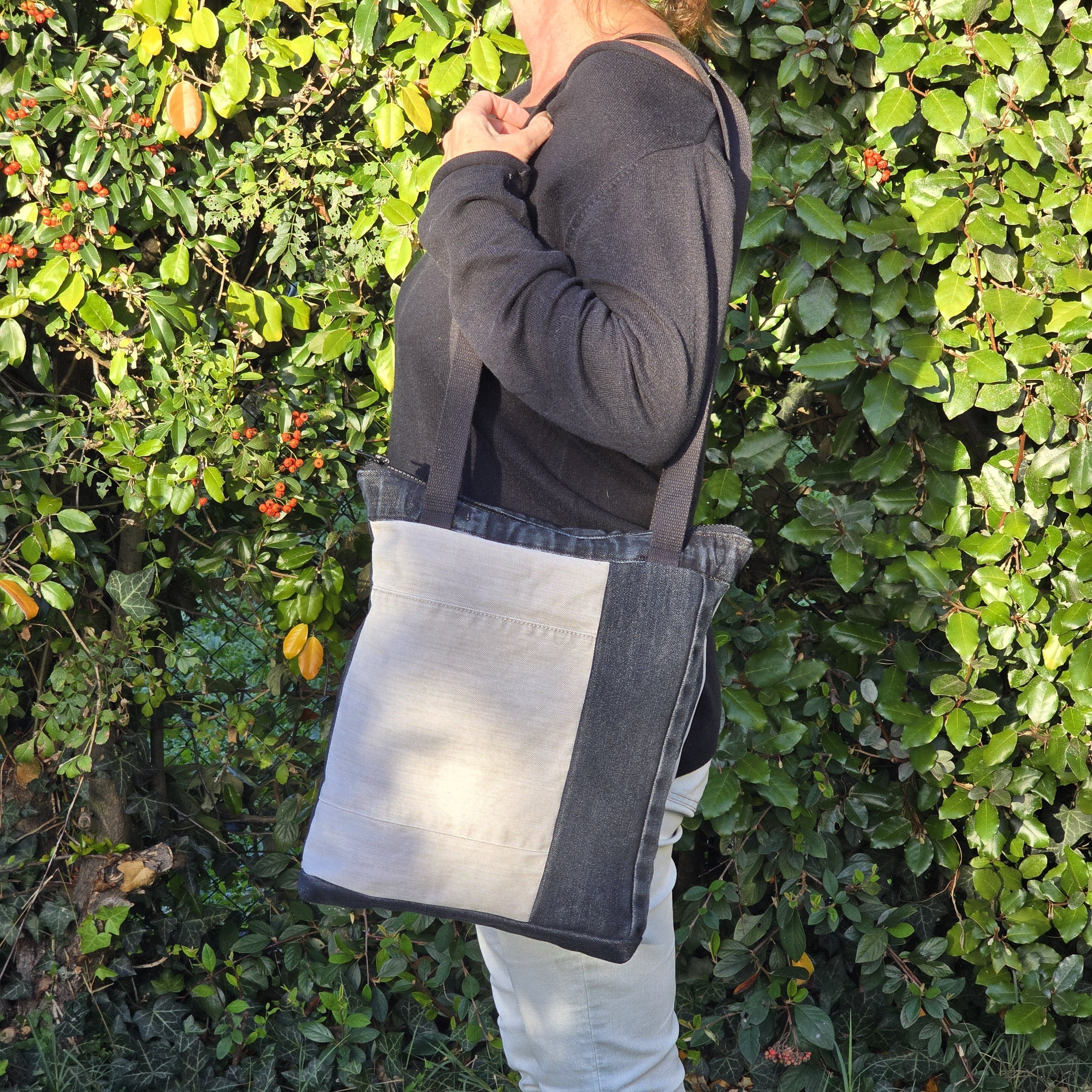 Sac &agrave; bandouli&egrave;re en jean recycl&eacute; noir et gris avec empi&egrave;cements.