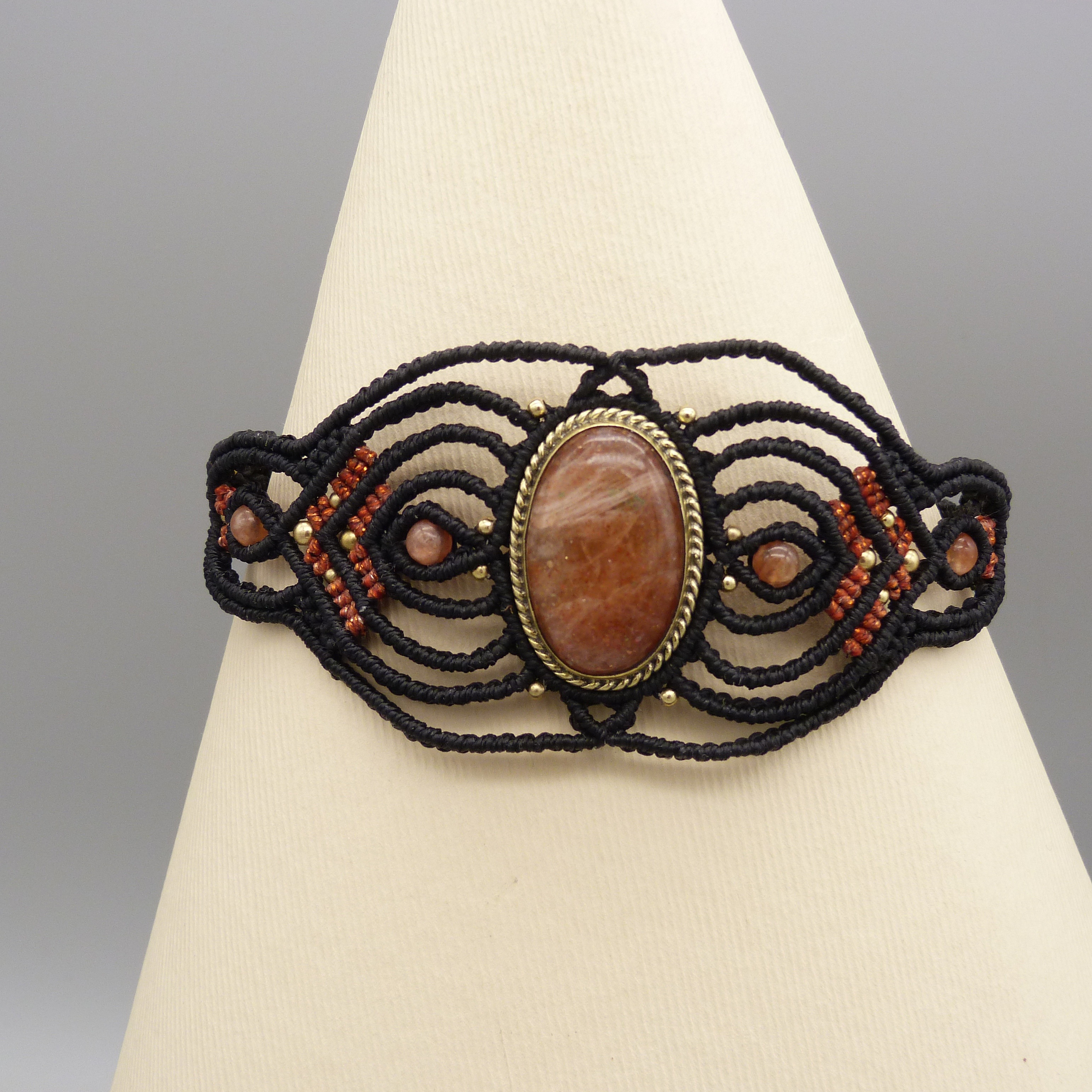 Manchette noire en micro-macram&eacute; avec une pierre de soleil