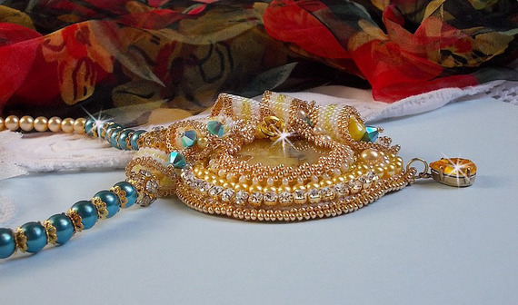 Haute-Couture Sunflower Gold vedhæng broderet med 24 karat forgyldte frøperler, en opal fra Madagaskar og Swarovski-krystaller.