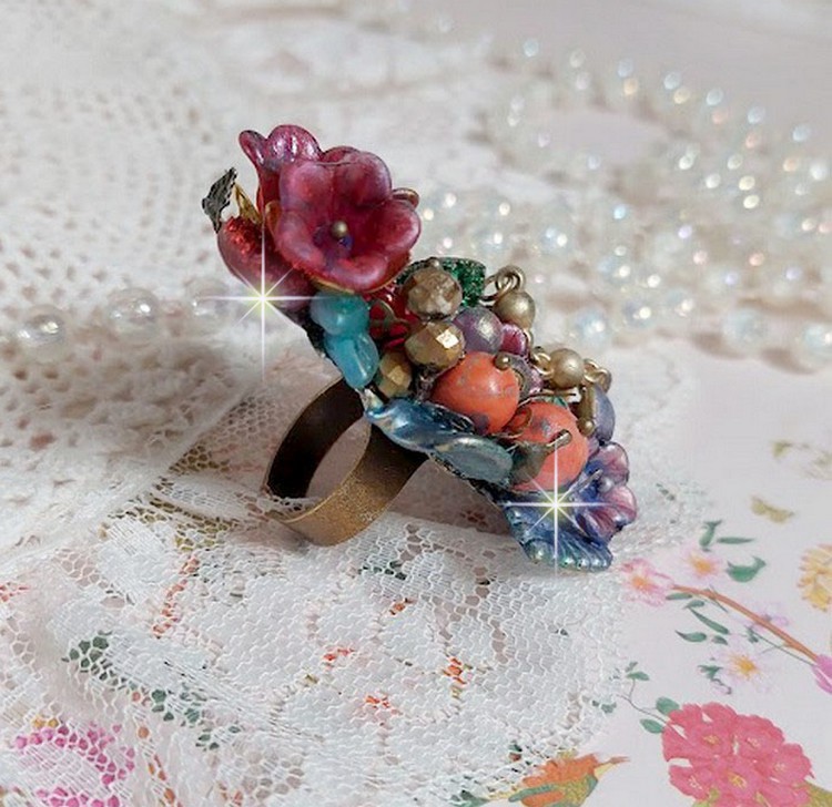 Bague Onia pour une composition florale créée avec des cristaux, fleurs : perles, clochettes, pensées, gouttes Druzy,  pierre de gemme : le Corail, perles cloisonnées et bague ovale en Laiton