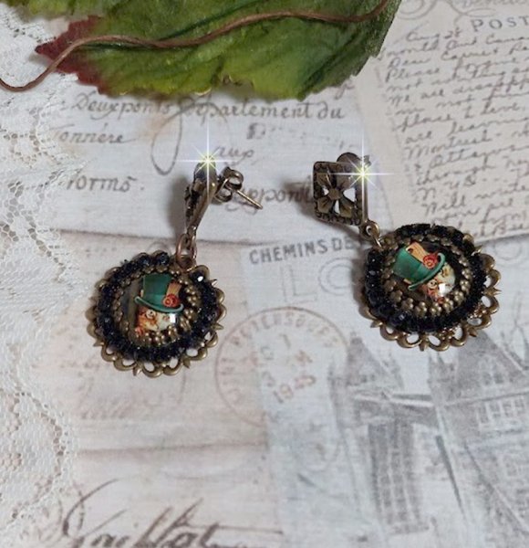 BO Chatou Steampunk mont&eacute;es avec cabochons loupes repr&eacute;sentant des chats en chapeau haut de forme Vert avec un m&eacute;daillon orn&eacute;s d&rsquo;une cha&icirc;ne strass Noire sur estampes Bonze et clous d'oreilles Laiton