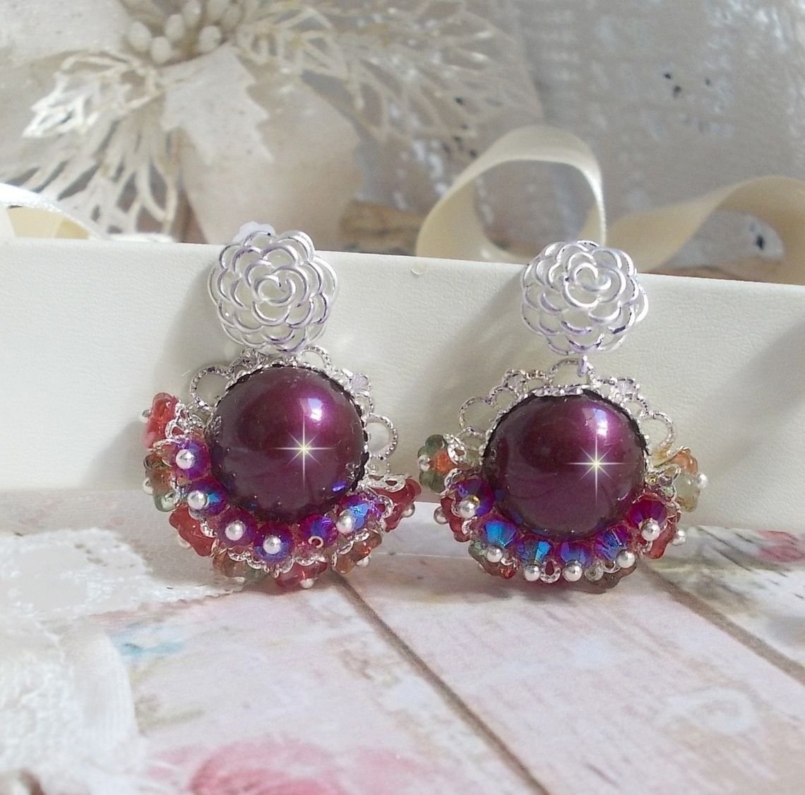 BO Fleurs de Cabaret avec des cabochons ronds Bordeaux en cristal de Swarovski, des toupies Fuschia, des fleurs clochettes en verre sur une base pendentif argentée et des clous d'oreilles en métal