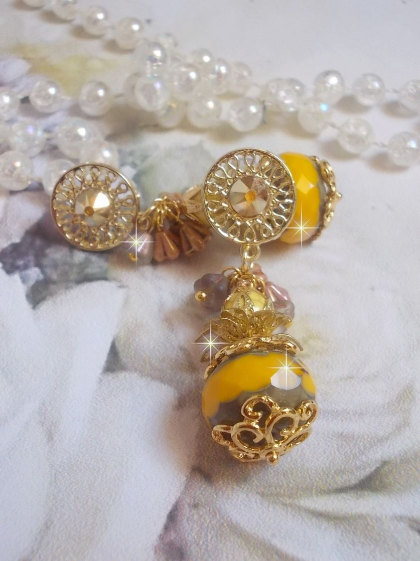 BO Lumière Opale Jaune avec des perles potirons jaunes à laquelle s’ajoute des fleurs, cabochons en cristal, coupelles et perles rondes. Montés sur clous d’oreilles en Métal. Un style moderne