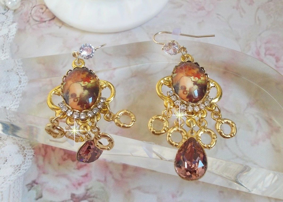 BO Paris représentant une jeune femme à Paris, orné d’une chaîne strass Cristal/Doré avec des breloques, des pendants ovales Blush Rose, montés sur des crochets en plaqué Or. Paris en mode vintage.