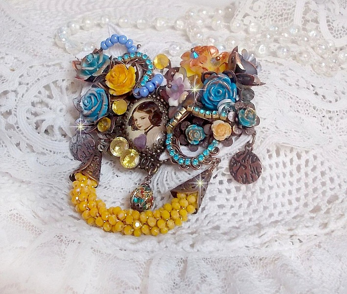 Broche artisanale baroque ornée de fleurs et perles jaunes.