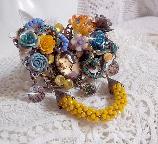 Broche artisanale baroque ornée de fleurs et perles jaunes.
