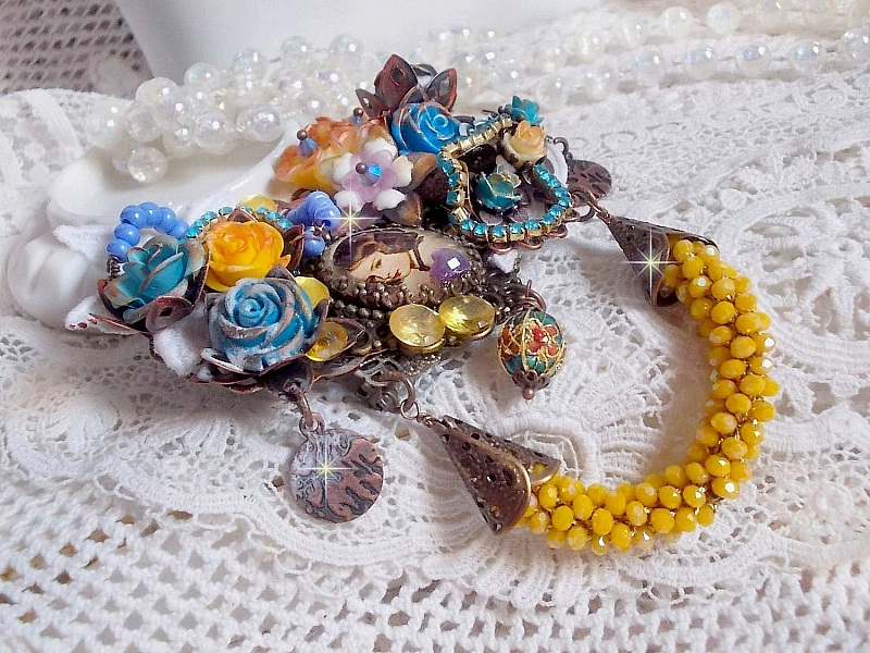 Broche baroque artisanale ornée de fleurs et perles jaunes.