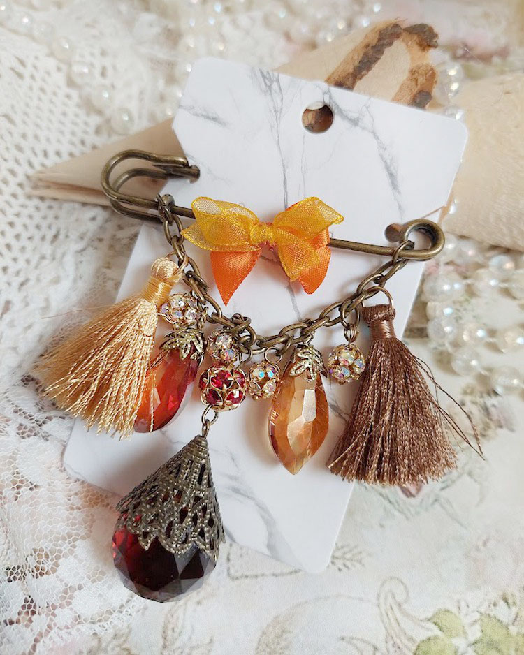 Broche Méline des Bois épingle créée avec rondes strass, pompons, gouttes verre, chaîne et boule de bohème en verre