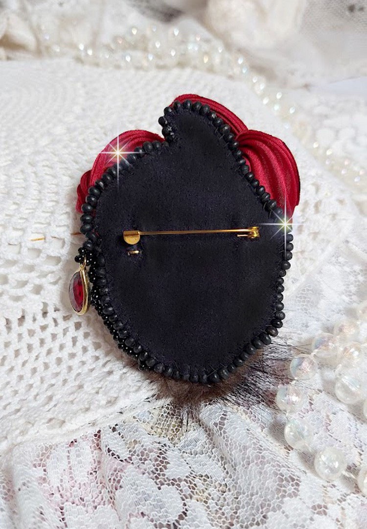 Broche Rouge et Noir brodée avec un ruban de soie de couleur Rouge Foncé à laquelle s’ajoute des toupies Siam AB , perles rondes facettées aplaties Antique Noires et goutte sur un support Doré