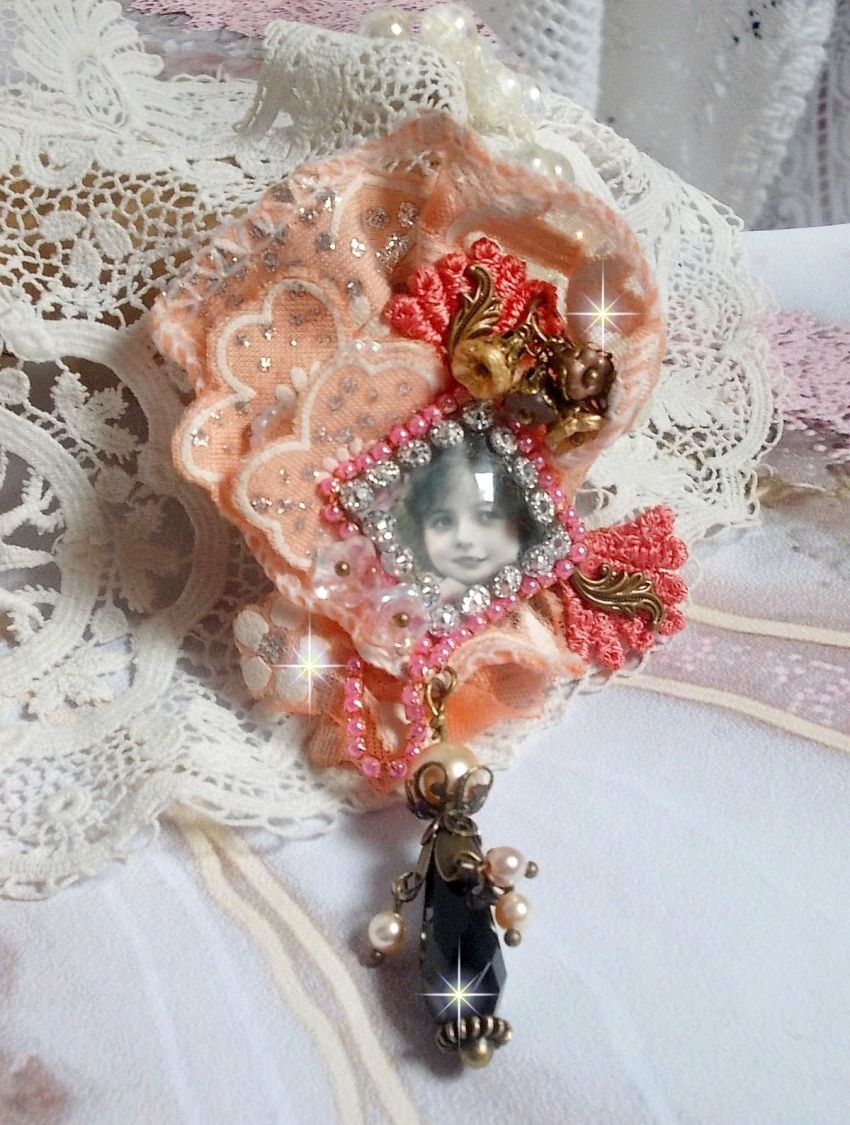 Rustik Rose broche skabt med en cabochon, der forestiller en smilende pige, orange rhinestone og Rose blonder, krystaller, glasperler og diverse tilbehør