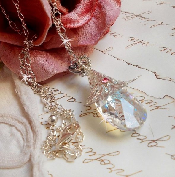 Blomsterhalsk&aelig;de i s&oslash;lv med et smukt vedh&aelig;ng i Swarovski krystal, en hjerteformet s&oslash;lvindsats med k&aelig;de, ringe, l&aring;s og forl&aelig;ngerk&aelig;de i s&oslash;lv 925/1000