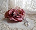 Sur une rose, le collier brille par ces éclats de cristaux