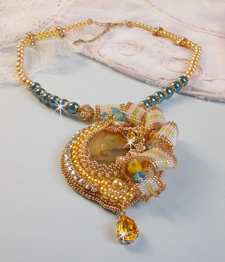 Haute-Couture Sunflower Gold vedhæng broderet med 24 karat forgyldte frøperler, en opal fra Madagaskar og Swarovski-krystaller.