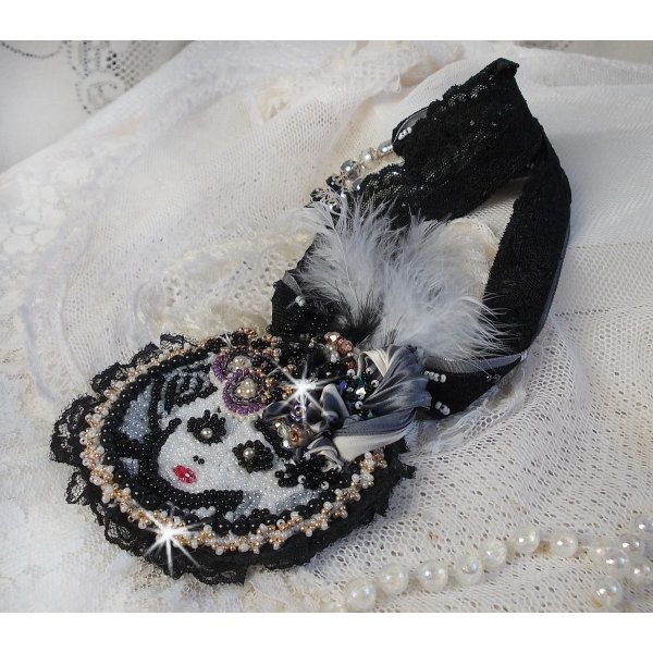 Sort fe vedh&aelig;ngsk&aelig;de med en smuk silke- og perlehat.