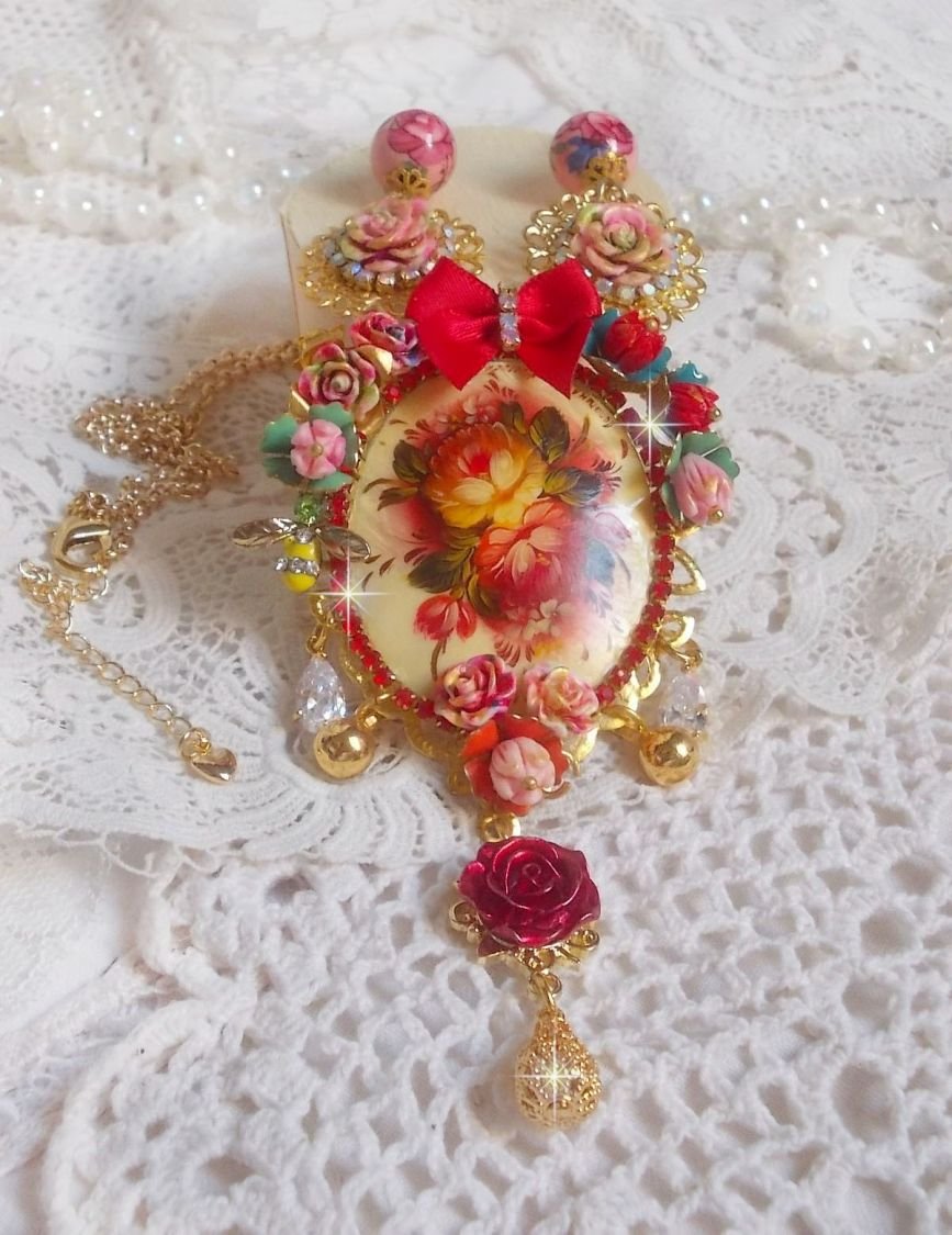 Collier Roseraie Provençale crée avec des perles en verre, céramique, résine, des accessoires en plaqué Or et autres avec un nœud en satin Rouge