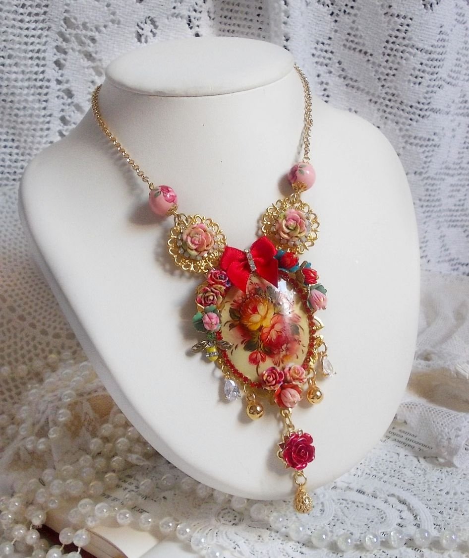 Collier Roseraie Provençale crée avec des perles en verre, céramique, résine, des accessoires en plaqué Or et autres avec un nœud en satin Rouge