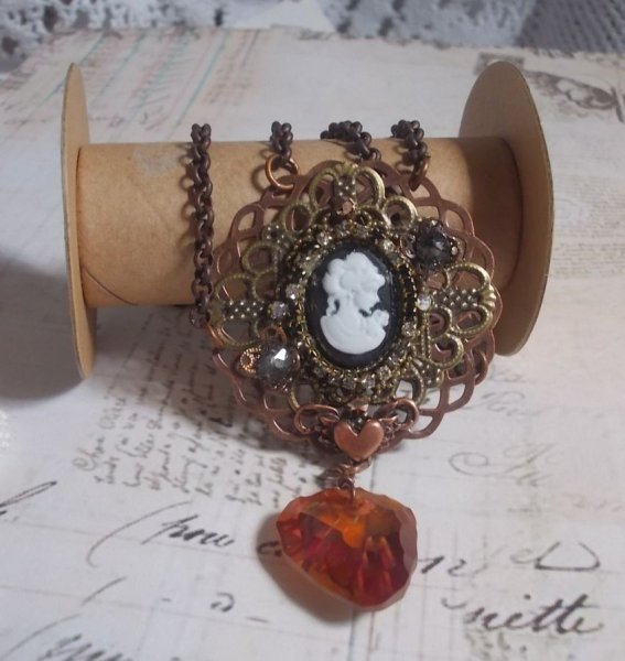 Watson halsk&aelig;de skabt med prints, et Swarovski krystal vedh&aelig;ng med et retro look, messing tilbeh&oslash;r og en cabochon i harpiks