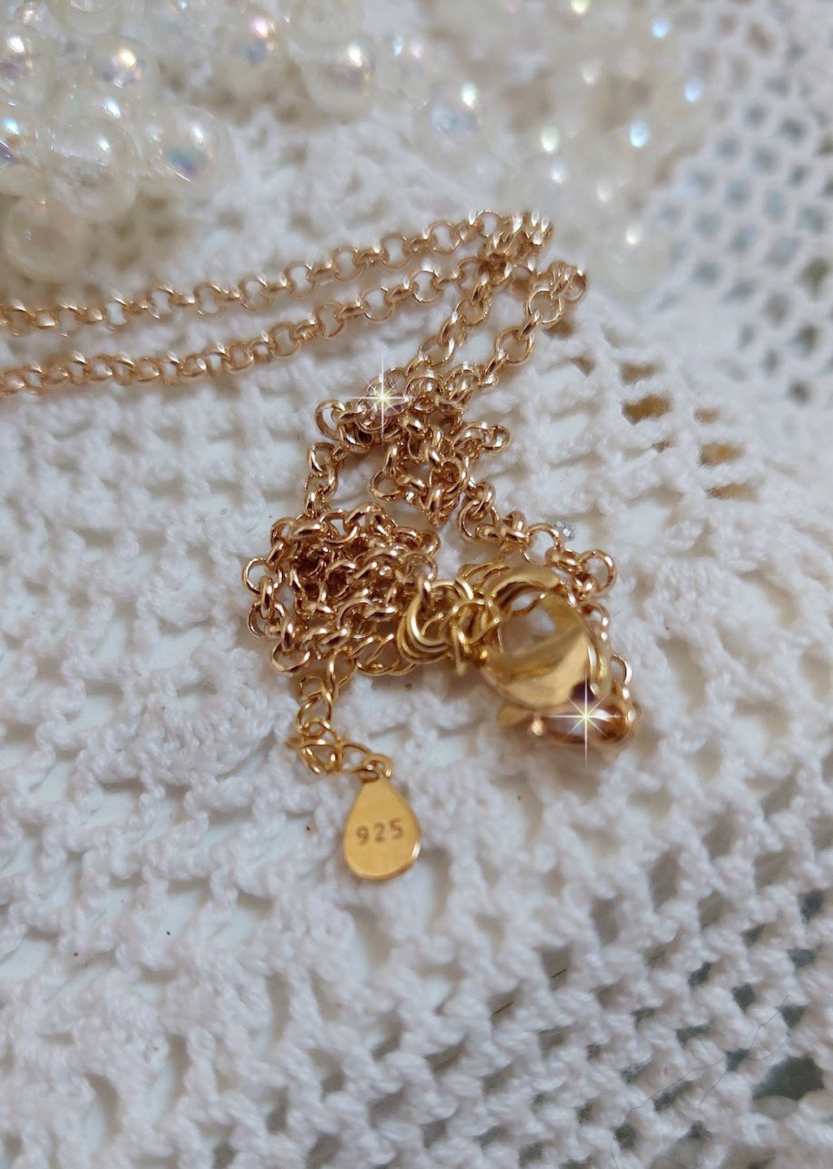 Pendentif Aurore mont&eacute; avec un motif &eacute;maill&eacute; aux couleurs du soleil &agrave; laquelle s&rsquo;ajoute perles nacr&eacute;es, breloques, poires avec Zircons, perles, ruban sur une b&eacute;li&egrave;re Argent 925 et une cha&icirc;ne plaqu&eacute; Or