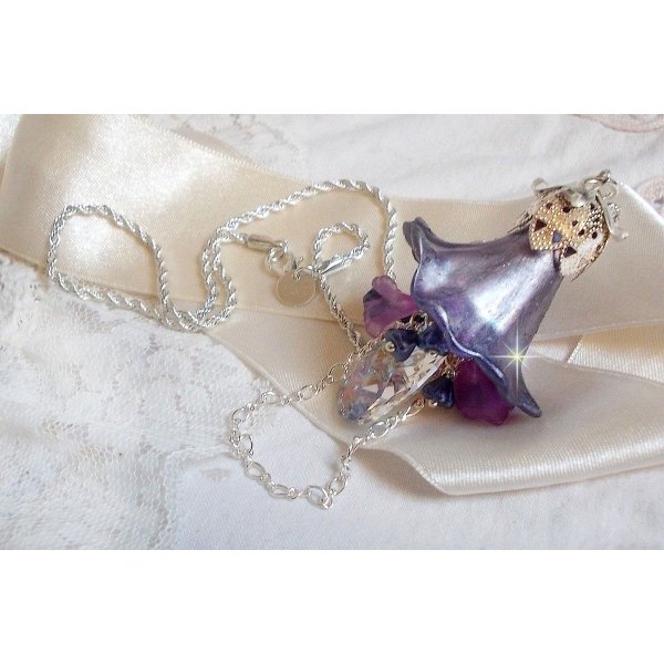 Pendentif Eclat de Cristal monté avec une goutte en Cristal, fleurs en Verre, fleurs lucites dont une plus grande peinte à la main avec paillettes Argentées. Une composition florale