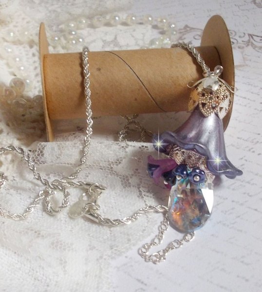 Pendentif Eclat de Cristal mont&eacute; avec une goutte en Cristal, fleurs en Verre, fleurs lucites dont une plus grande peinte &agrave; la main avec paillettes Argent&eacute;es. Une composition florale