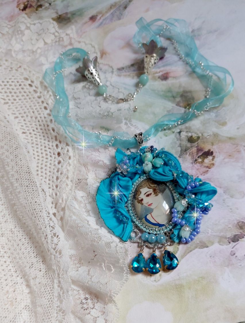 Pendentif Mademoiselle au style rétro avec cabochon d’une femme souriante, orné d’un ruban de soie Bleu, cristaux, perles verre : rocailles et roses, coupelles et chaîne Argent 925/1000