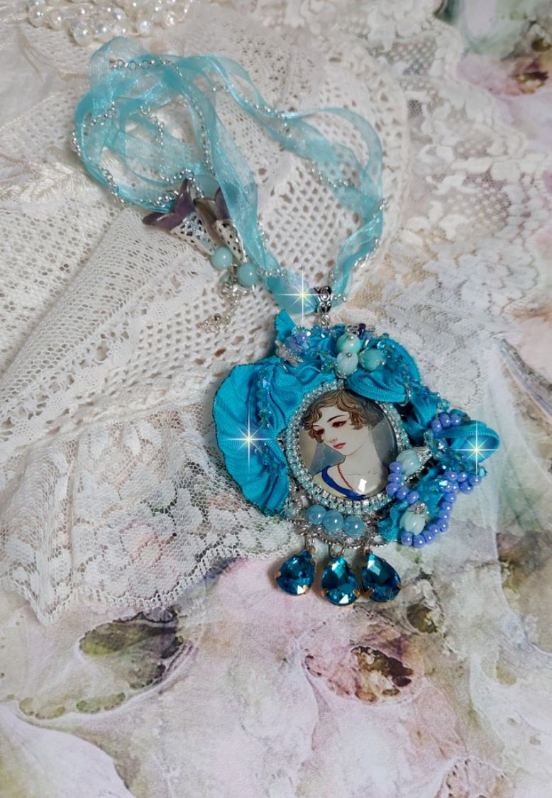 Pendentif Mademoiselle au style rétro avec cabochon d’une femme souriante, orné d’un ruban de soie Bleu, cristaux, perles verre : rocailles et roses, coupelles et chaîne Argent 925/1000