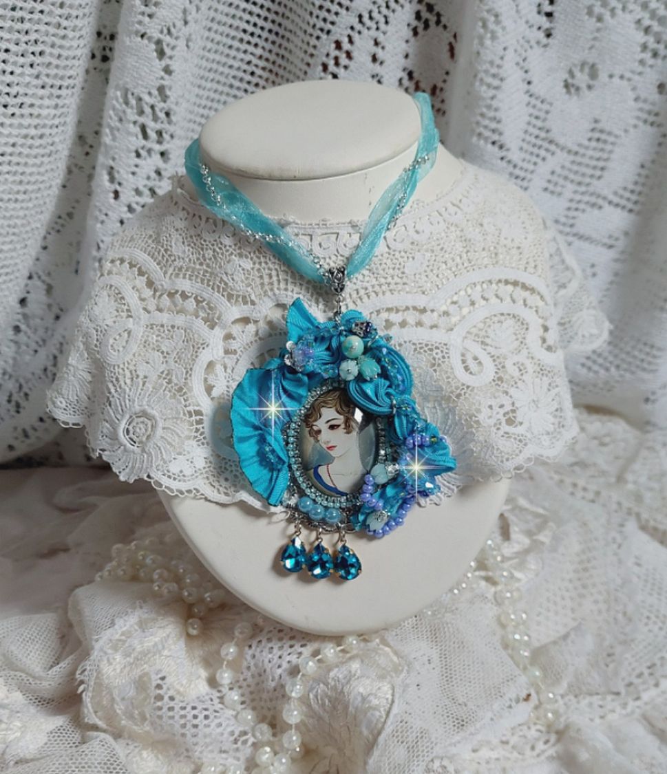 Pendentif Mademoiselle au style rétro avec cabochon d’une femme souriante, orné d’un ruban de soie Bleu, cristaux, perles verre : rocailles et roses, coupelles et chaîne Argent 925/1000