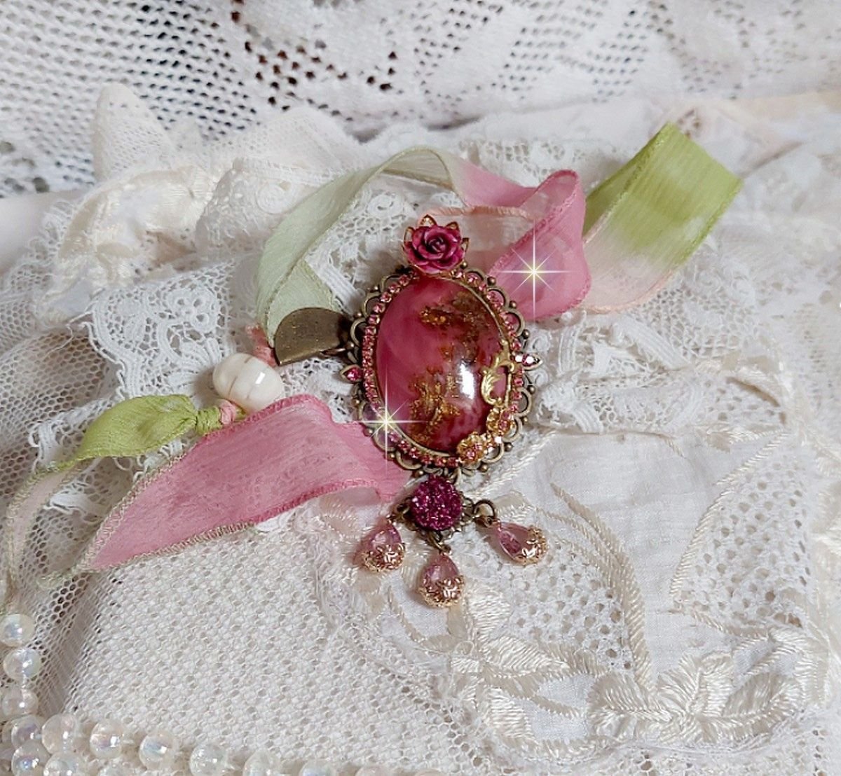 Pendentif Pampelone Fuchsia Haute Couture avec un cabochon artisanal et feuilles d’or, orné de strass, cristaux Roses, rose en résine, breloques, entretoises dentelles, Murano et ruban de soie