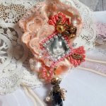 Rustik Rose broche skabt med en cabochon, der forestiller en smilende pige, orange rhinestone og Rose blonder, krystaller, glasperler og diverse tilbehør