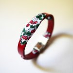 Florâme-armbånd med bånd af kirsebærfrugter på rødt læder