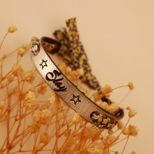 Florâme-armbånd indgraveret med gule blomster i liberty-bånd på sølvfarvet læder