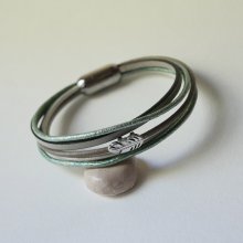 Multi-læderarmbånd i nuancer af beige, lysegrøn og perlemor, dekoreret med en lille fjer