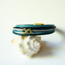 Flerleddet armbånd i blåtonet læder med infinity-motiv i guld